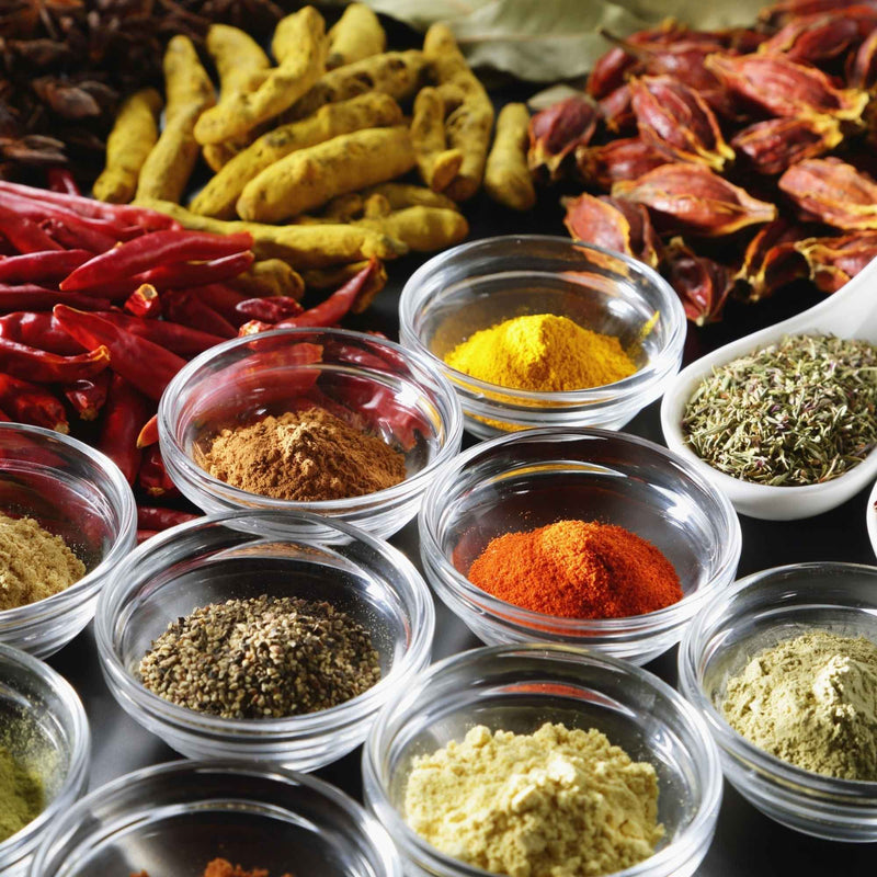 Mélange coloré d’épices médicinales comme curcuma, cannelle, gingembre et clous de girofle, traditionnellement utilisées pour soutenir santé et bien-être