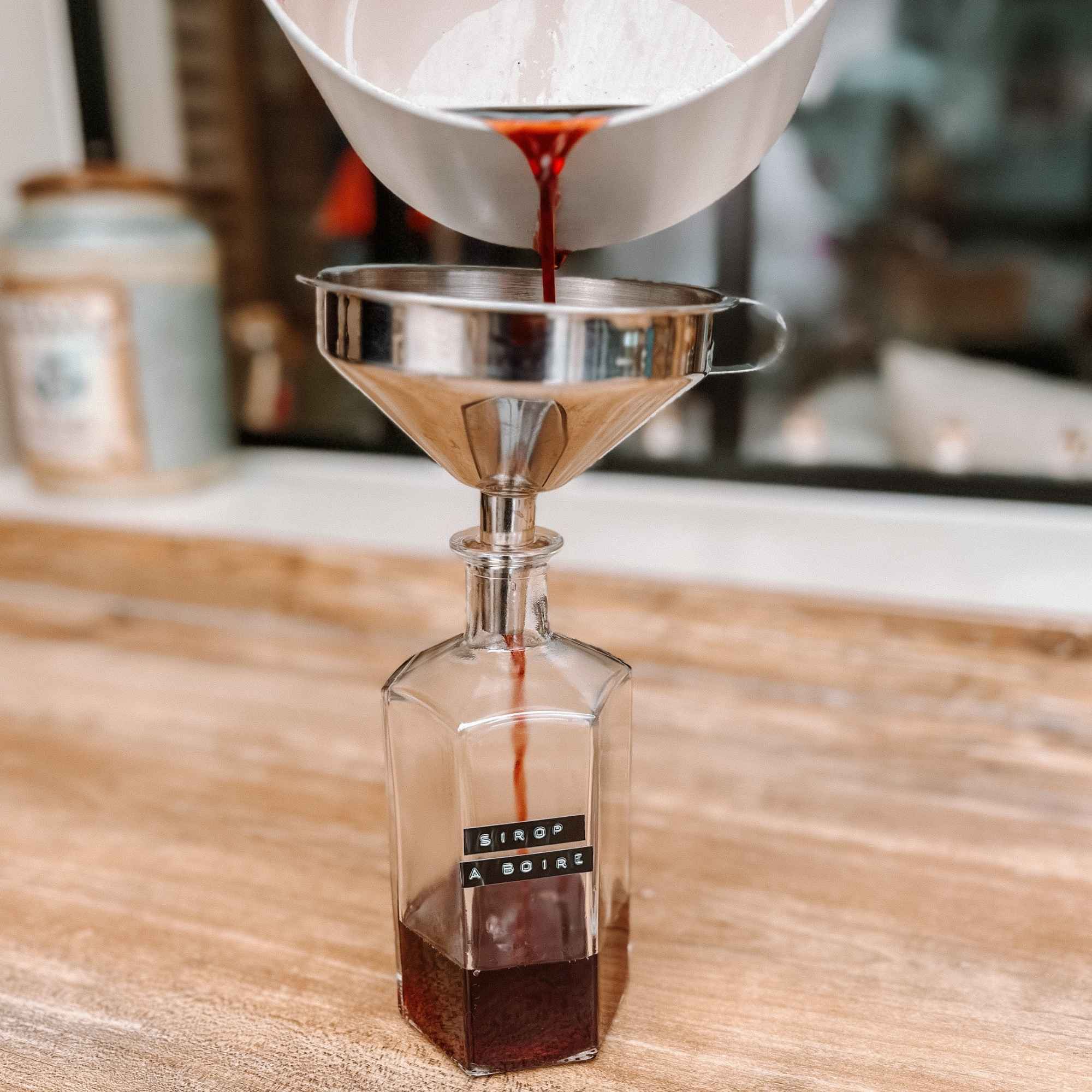 Sirop fait maison versé dans une bouteille en verre réutilisable