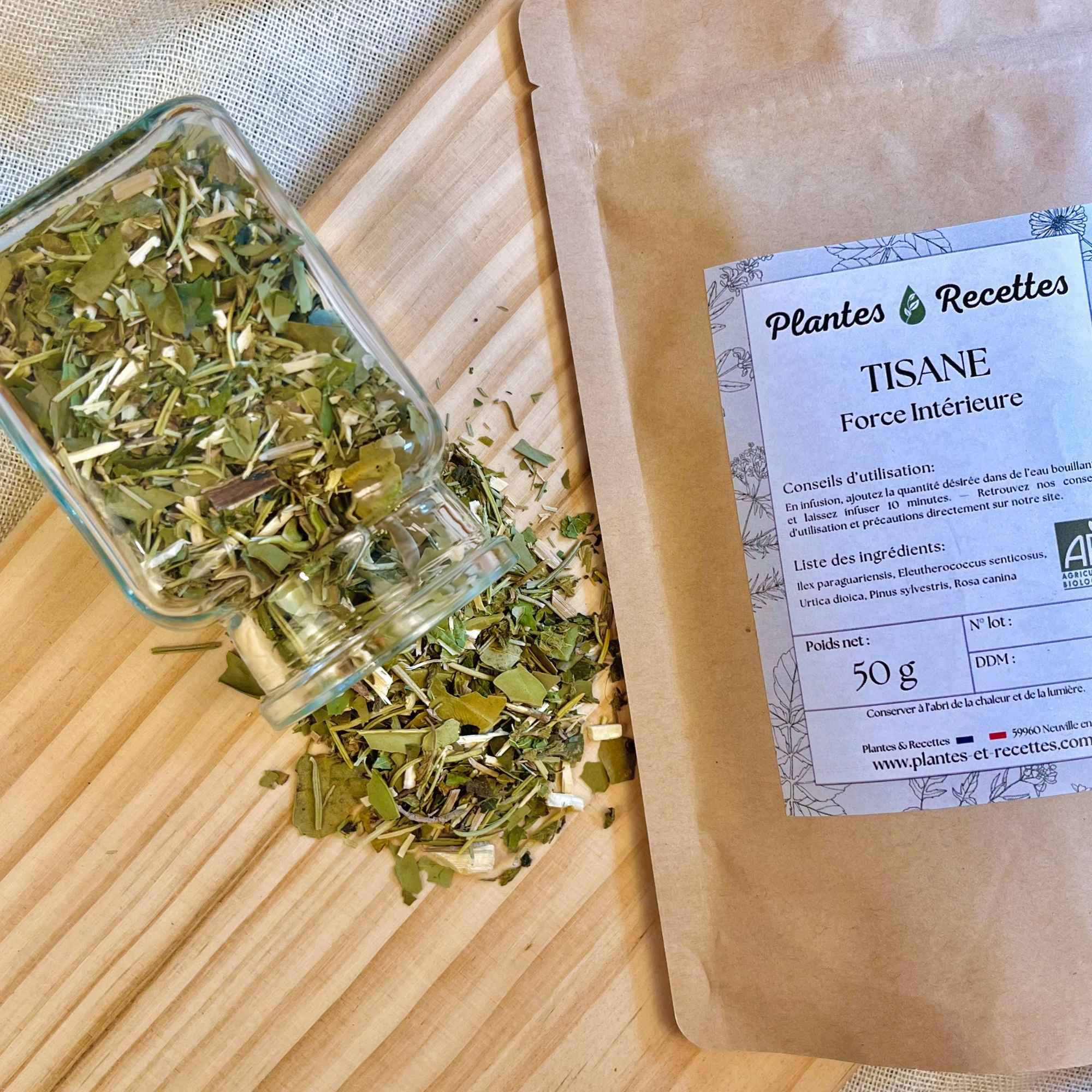Tisane Force Intérieure – focus sur le mélange de plantes avec le paquet en arrière-plan. Plantes et Recettes.