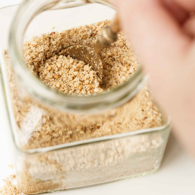 Vue rapprochée d’un bol de gomasio artisanal, mélange doré de graines de sésame grillées et de sel naturel