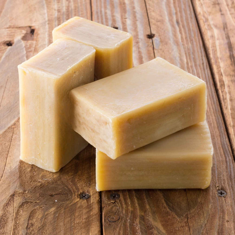 Savon artisanal à la terre de Sommières posé sur un tissu, prêt à l’emploi pour détacher naturellement les vêtements et textiles délicats.