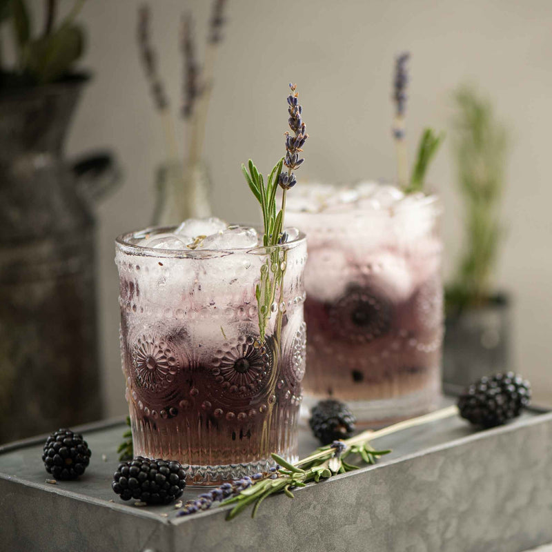 Flacon de sirop de lavande maison posé sur une table en bois, avec fleurs séchées en arrière-plan — Recette simple à base de lavande.