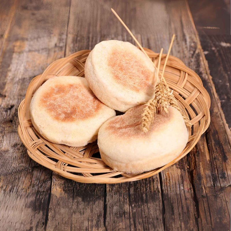 Petits pains muffins maison présentés dans un panier en osier sur une table rustique.