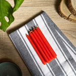 Ces bougies thaïlandaises rouges en bâton sont traditionnellement allumées dans les petits temples domestiques en Thaïlande