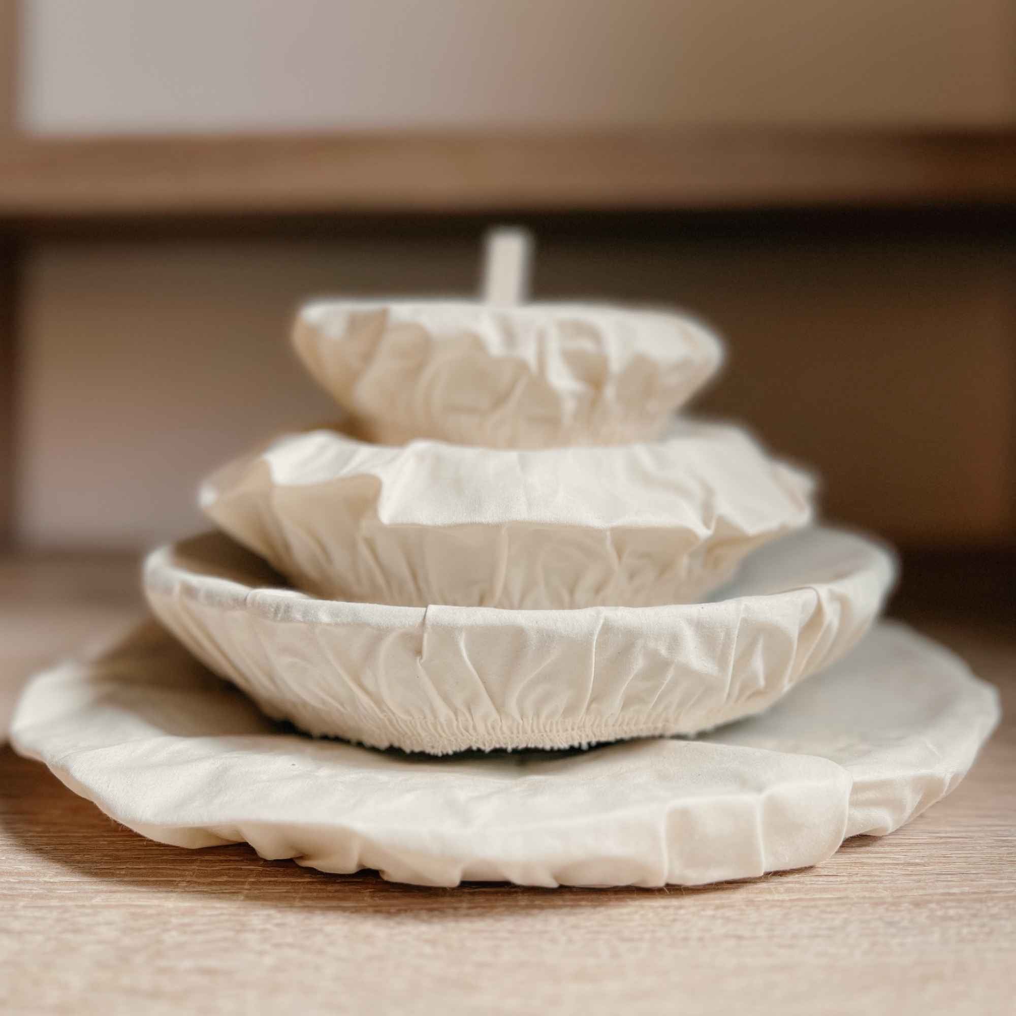 Vue de plusieurs couvercles en coton bio empilés, durables et lavables, une alternative écologique au film plastique.
