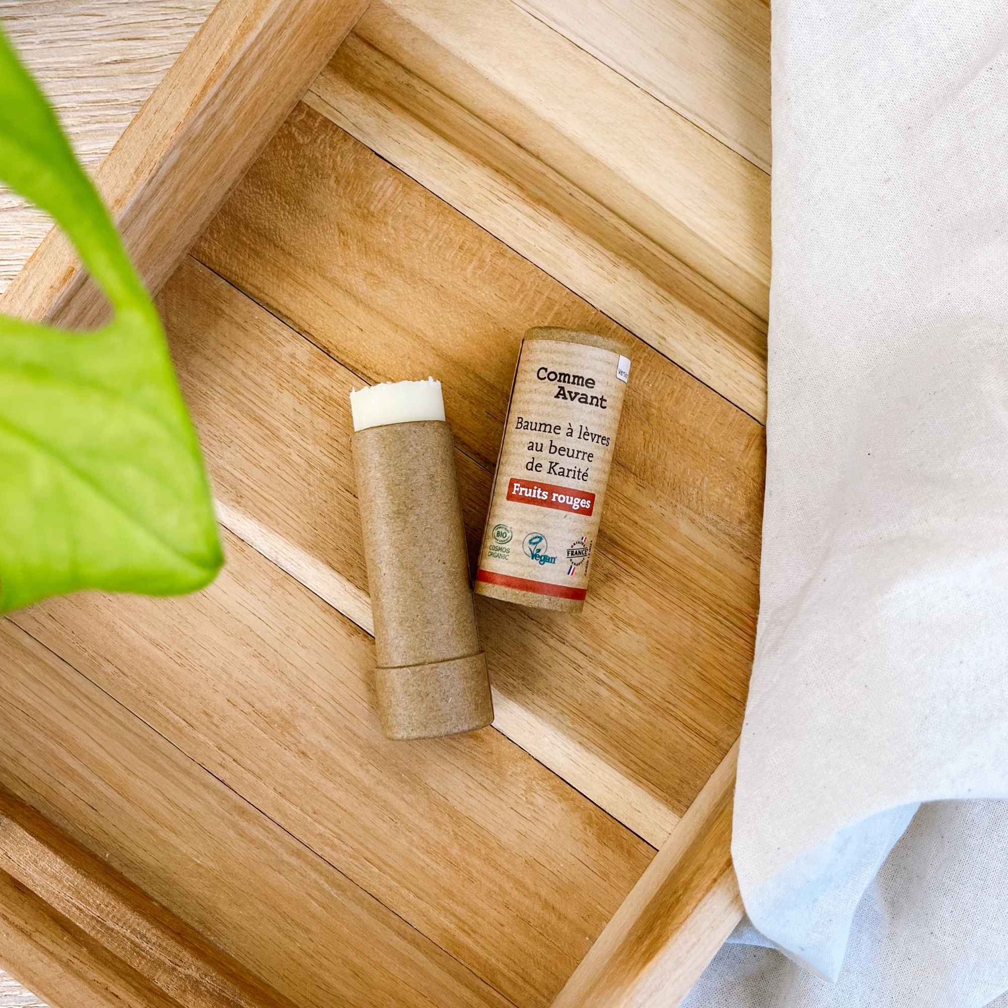 Baume à lèvres fruit rouge en mise en scène, parfait pour nourrir et adoucir les lèvres avec une touche gourmande.