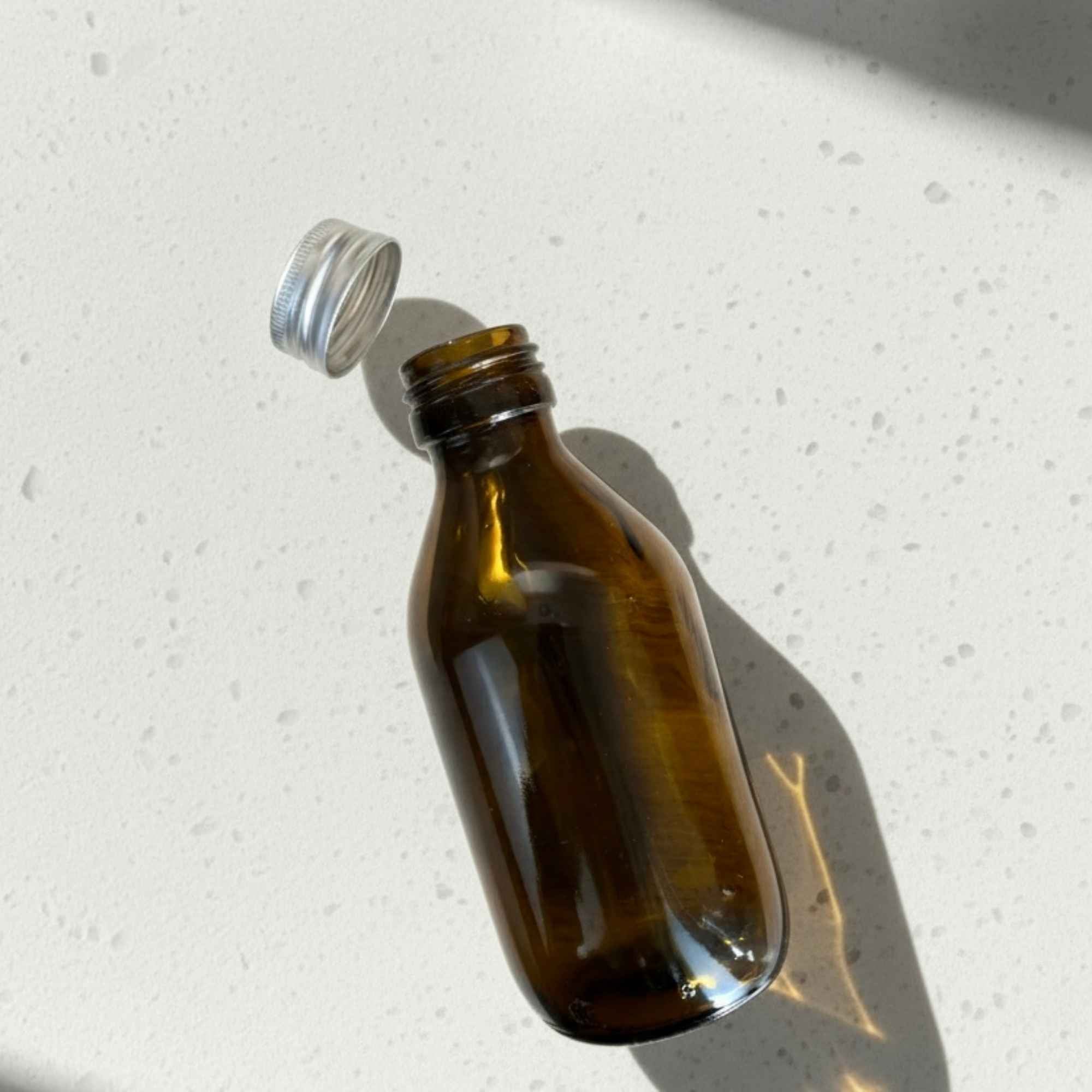 Bouteille à sirop 150 ml en verre ambré avec bouchon aluminium, qualité pharmaceutique.