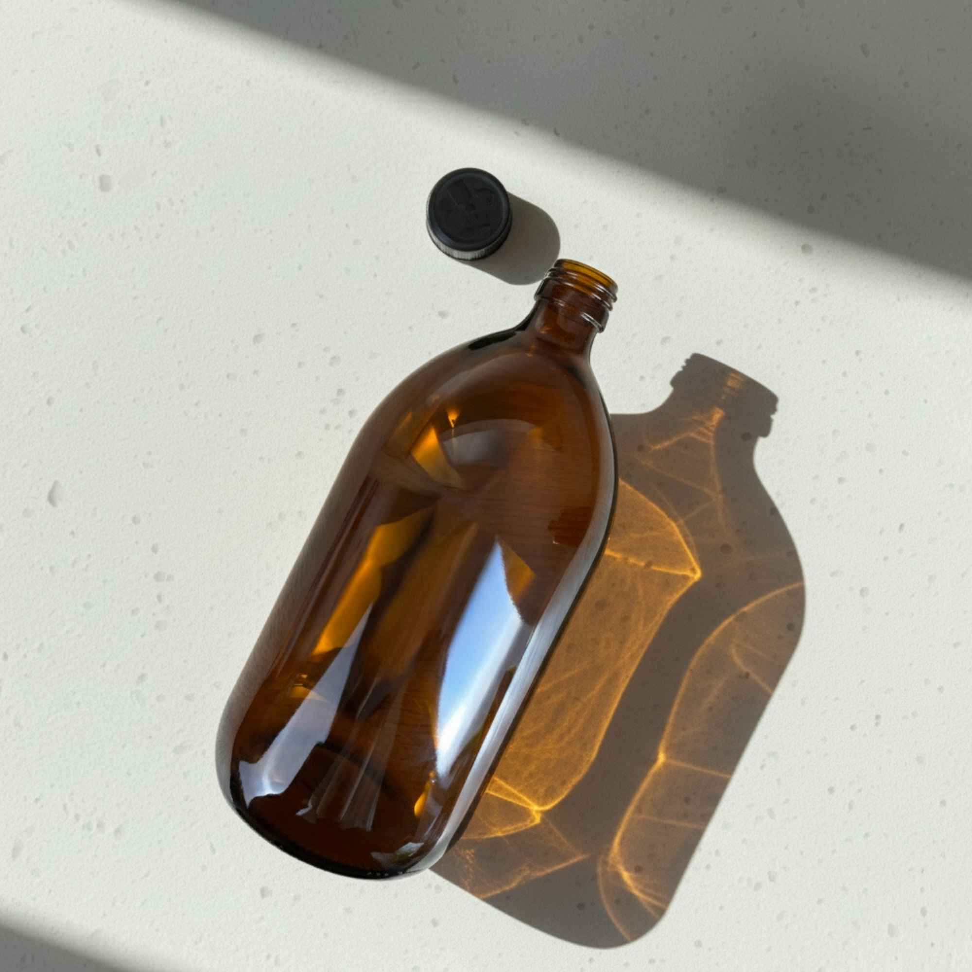 Bouteille en verre ambré 1000 ml avec bouchon sécurité enfants, qualité pharmaceutique.