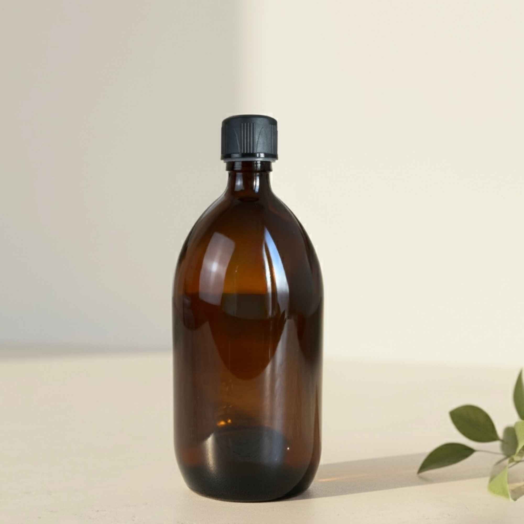 Bouteille ambrée avec bouchon sécurisé, idéale pour les liquides sensibles à la lumière.