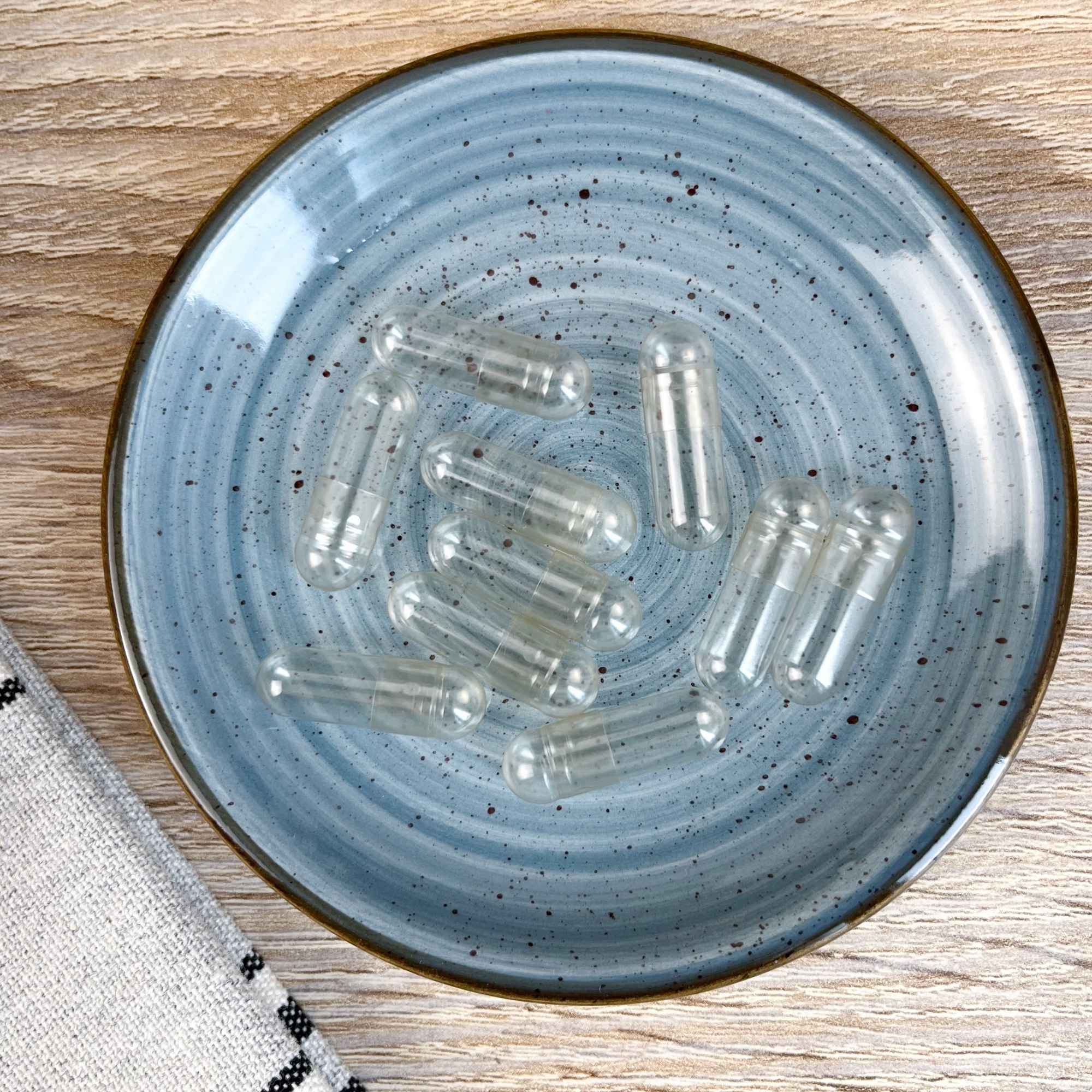 Gélules végétales taille 0 présentées sur une coupelle, accessoire pratique pour l’herboristerie et les préparations bien-être Plantes & Recettes.