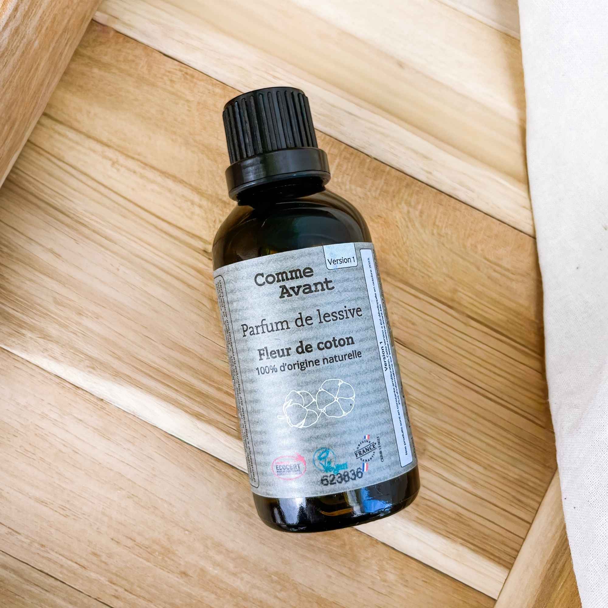 Parfum naturel pour lessive à la fleur de coton, format concentré, présenté en flacon recyclable.