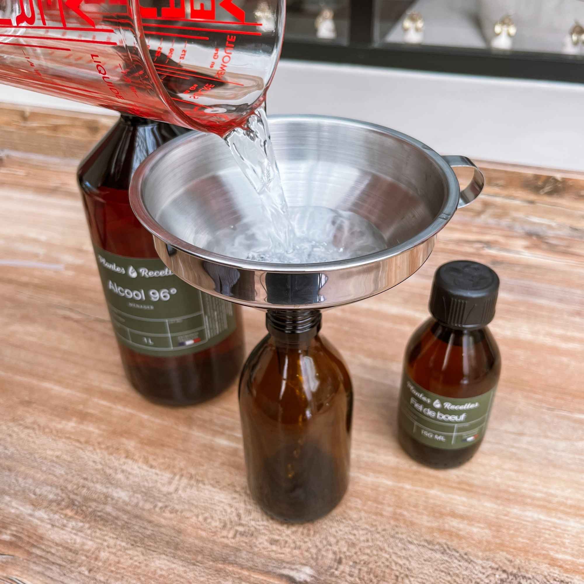 Verser l’alcool dans le flacon du kit recette pour créer un détachant textile maison simple et efficace.