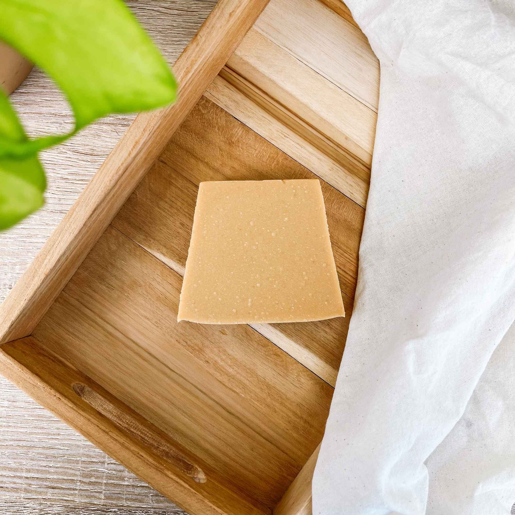 Savon au beurre de karité posé dans un décor naturel, idéal pour une toilette douce et respectueuse de la peau.