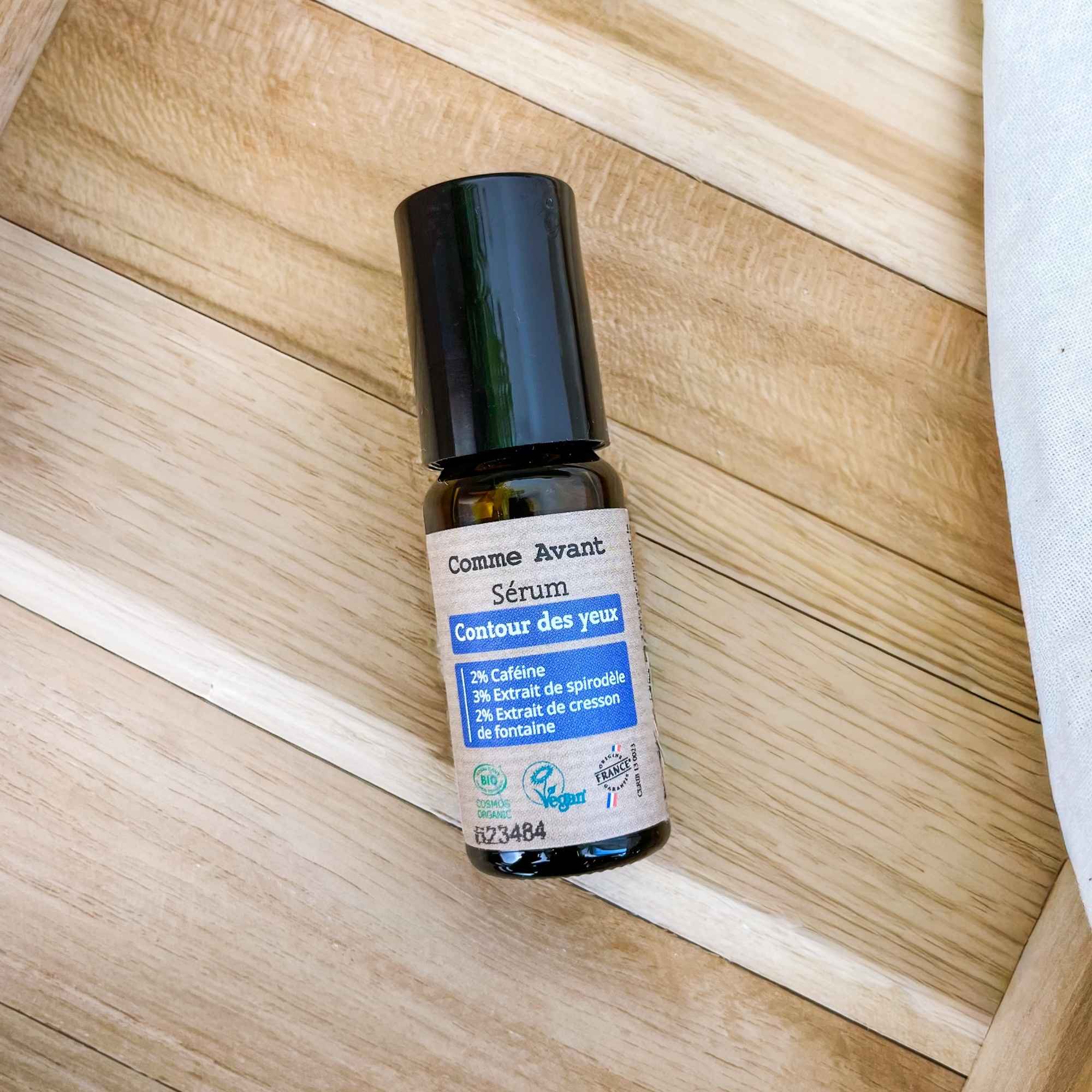 Flacon de sérum contour des yeux posé en mise en scène, idéal pour lisser et hydrater la zone du regard.