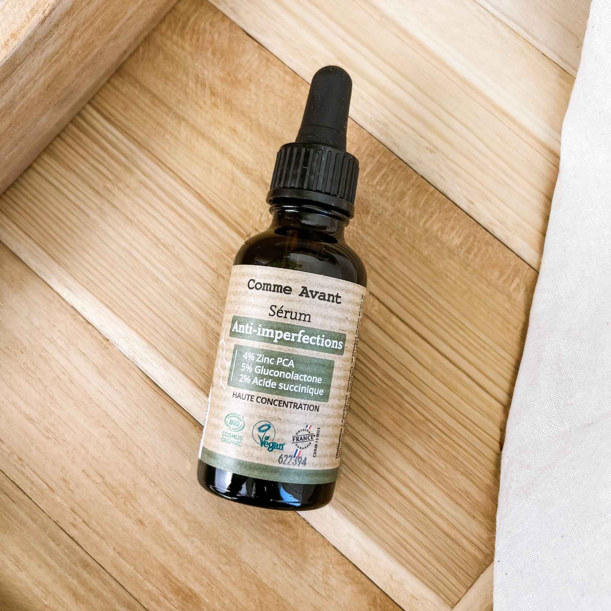 Flacon de sérum anti-imperfections posé en mise en scène, conçu pour purifier et rééquilibrer la peau au quotidien.