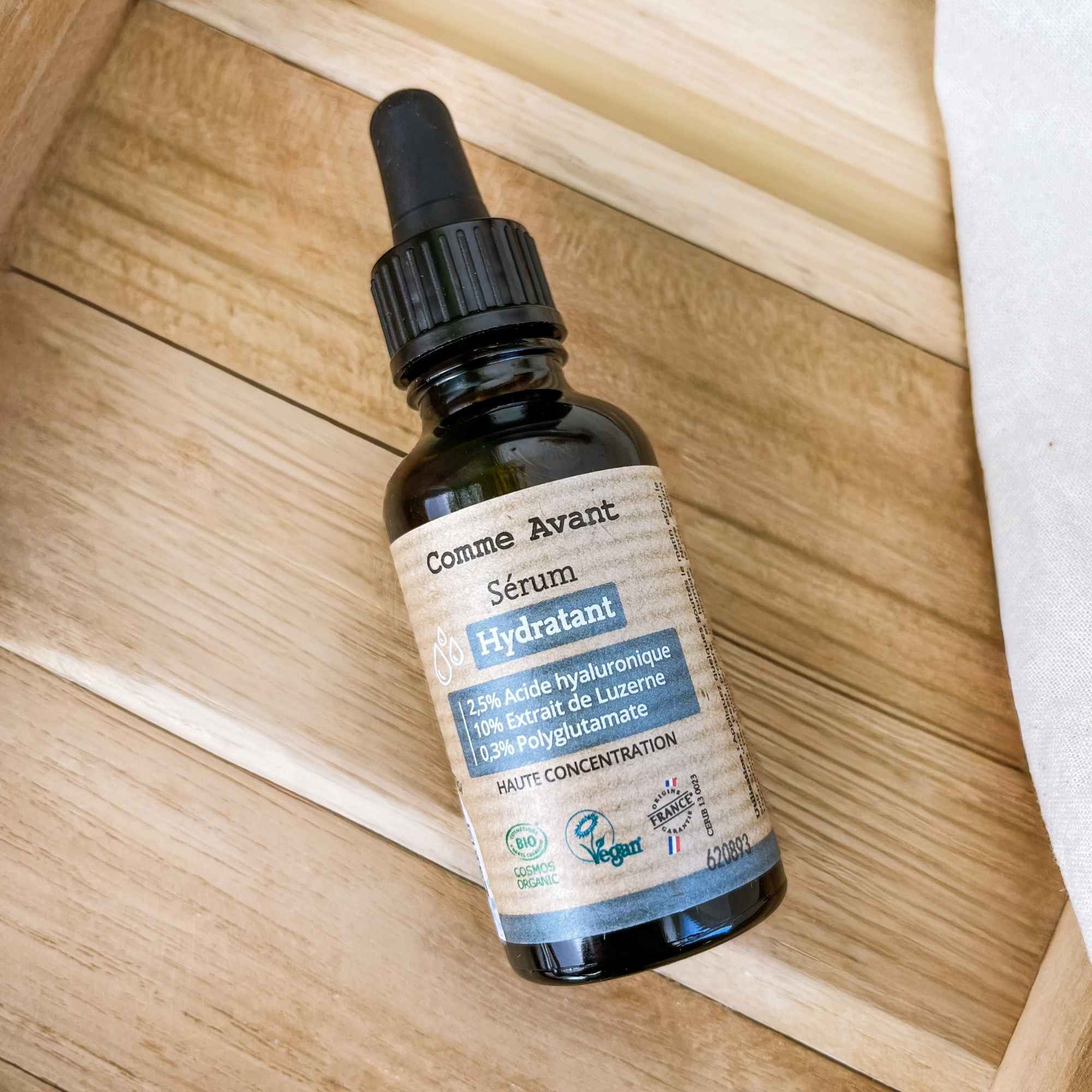 Flacon de sérum hydratant en mise en scène, idéal pour apporter douceur et confort à la peau.