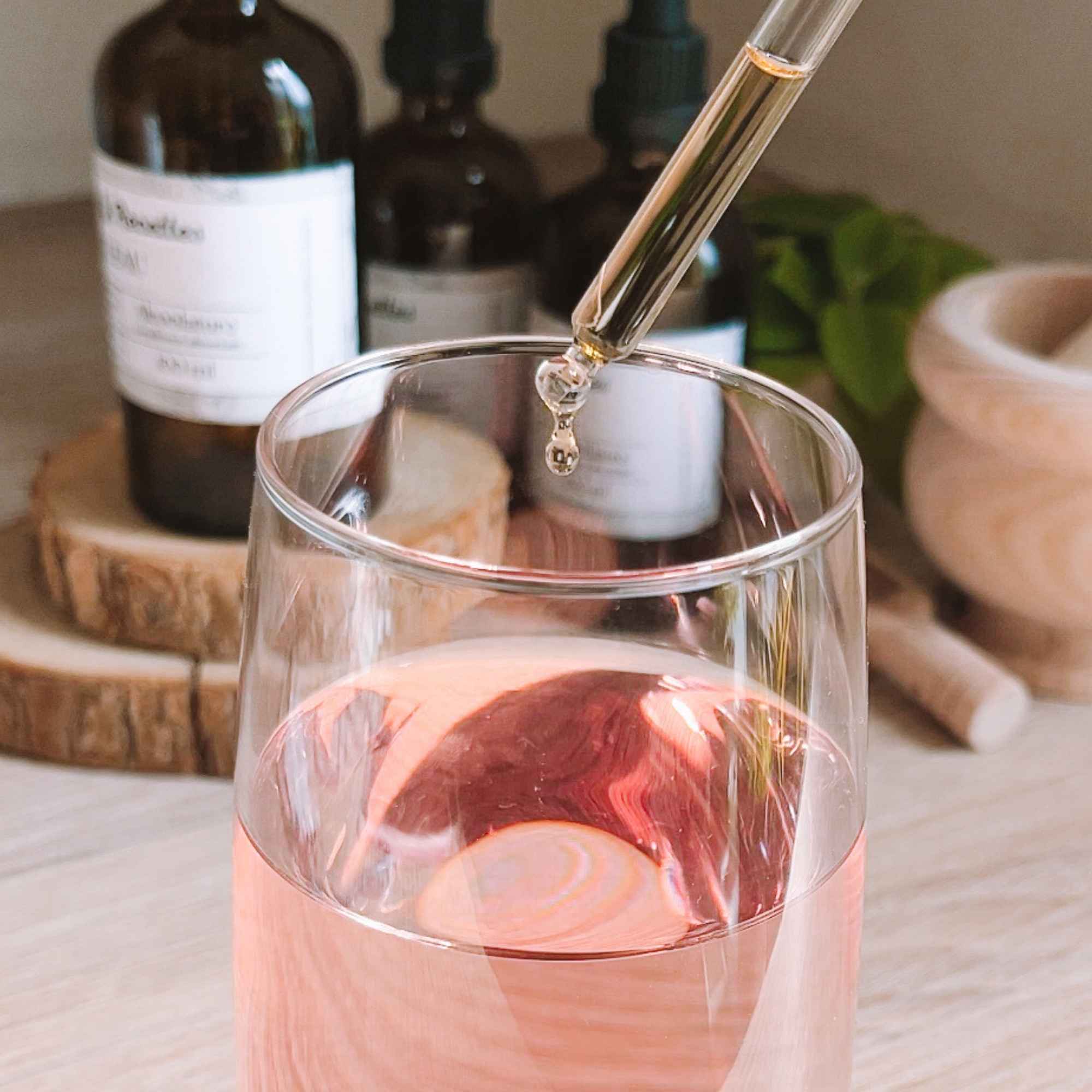 Ajout de teinture mère bio dans une boisson claire, usage simple et naturel des plantes avec Plantes & Recettes.